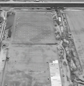 Aerial photo of construction site with foundation work and machinery.